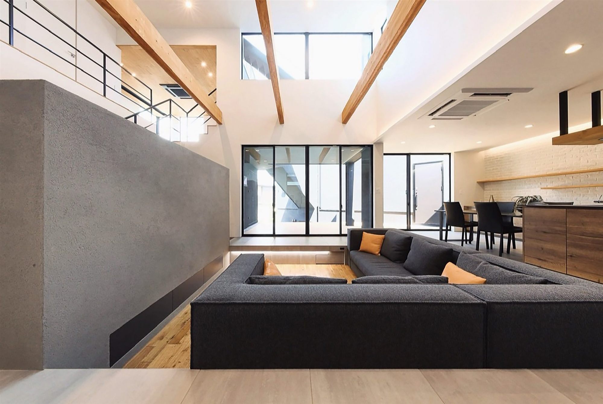表皮付きの梁が3本かかる吹き抜けと、ダウンフロアのリビング（ARCHI PRODUCTS 設計・施工）